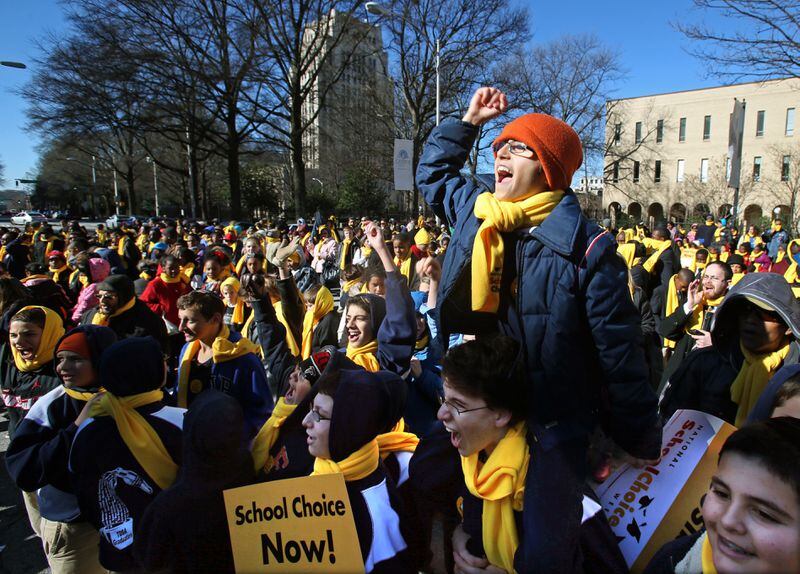 January 31, 2013 - Atlanta, Ga: Yehuda Benschitrit, 14, cheers as the name of his school, Torah Day School of Altanta, is announced as one of many schools that participated in the Georgia School Choice Celebration and Rally at the west entrance to the Georgia State Capitol Thursday morning in Atlanta, Ga., January 31, 2013. Benschitrit, an 8th grade student at Torah Day School of Atlanta, is sitting on the shoulders of fellow 8th grade student, Ben Bogart, 14. More than 2,000 public, private, and home school students met outside the Georgia State Capitol Thursday to call for the expansion of educational opportunities for kids. This is the fourth annual Georgia School Choice Celebration and Rally. JASON GETZ / JGETZ@AJC.COM