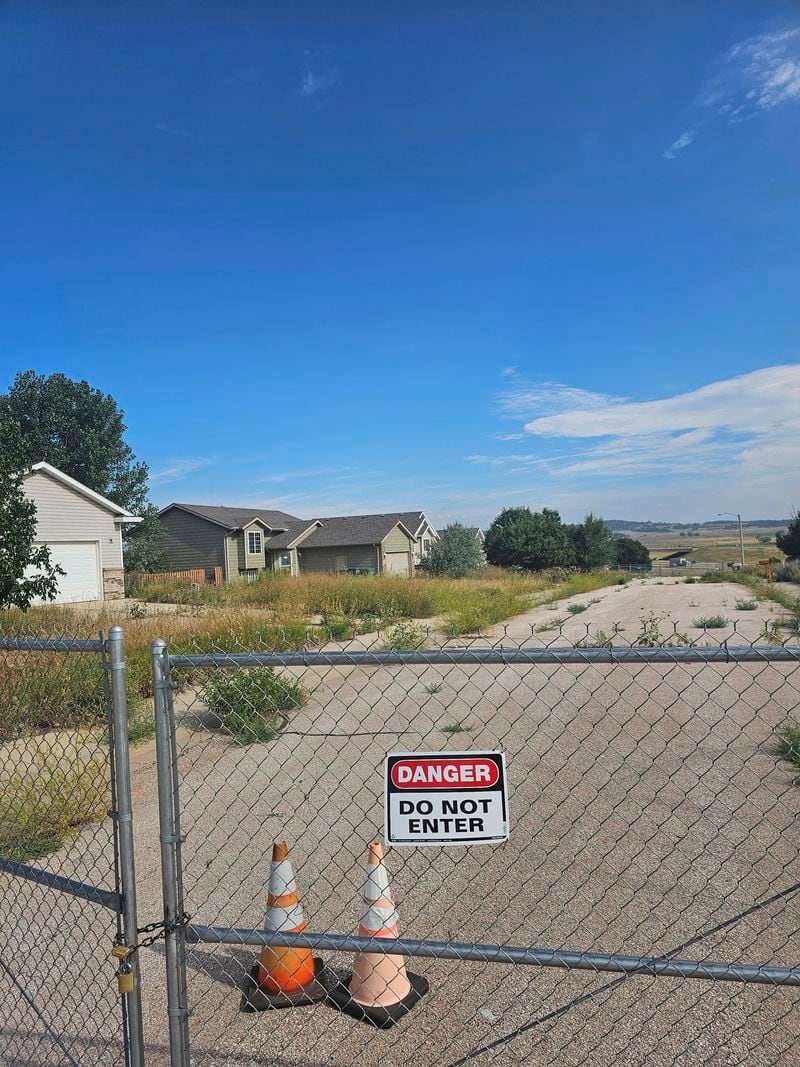 This photo taken April 27, 2022, by Tonya Junker shows a fence prohibiting people to enter due to a sinkhole in the Hideaway Hills neighborhood near Rapid City, S.D. (Tonya Junker via AP)