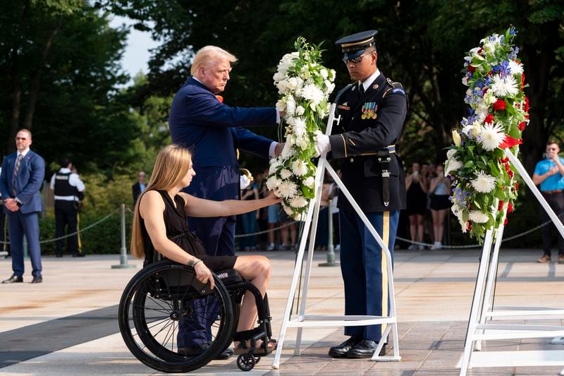 Former U.S. Marine Corps Cpl. Kelsee Lainhart left, and Republican presidential nominee former President Donald Trump place a wreath at the Tomb of the Unknown Solider in honor of the 13 service members killed at Abbey Gate, at Arlington National Cemetery, Monday, Aug. 26, 2024, in Arlington, Va. (AP Photo/Alex Brandon)