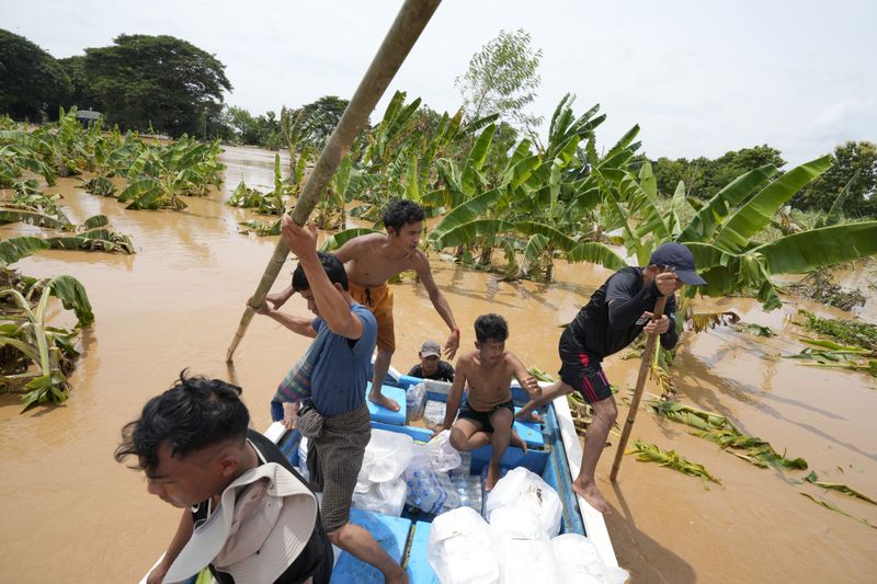 Local residents travel by boat on a flooded road in Naypyitaw, Myanmar, Saturday, Sept. 14, 2024. (AP Photo/Aung Shine Oo)