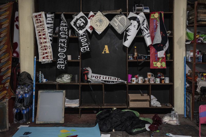 Political posters and stickers hang inside the print shop at the Raúl Isidro Burgos Rural Normal School in Ayotzinapa, Guerrero state, Mexico, Sunday, Aug. 25, 2024. (AP Photo/Felix Marquez)