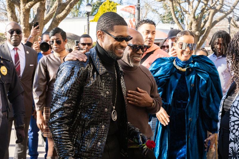 Usher and record executive L.A. Reid enter a homecoming rally for Usher at Clark Atlanta University in Atlanta on Wednesday, February 14, 2024. Along with other honors, Amazon presented a $25,000 donation to Usher’s New Look Foundation. (Arvin Temkar / arvin.temkar@ajc.com)