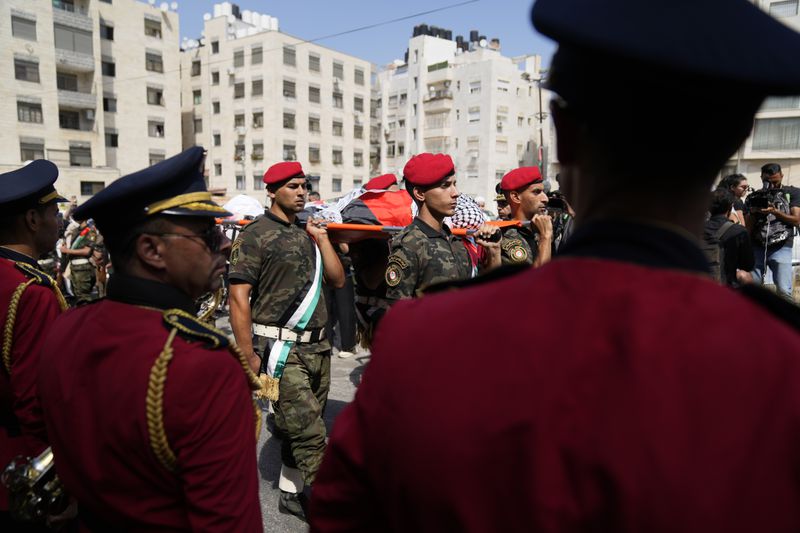 A Palestinian honor guard carries the body of Aysenur Ezgi Eygi, 26, who was fatally shot by Israeli soldiers while participating in an anti-settlement protest in the West Bank, during her funeral procession in the West Bank city of Nablus, Monday, Sept. 9, 2024. (AP Photo/Nasser Nasser)