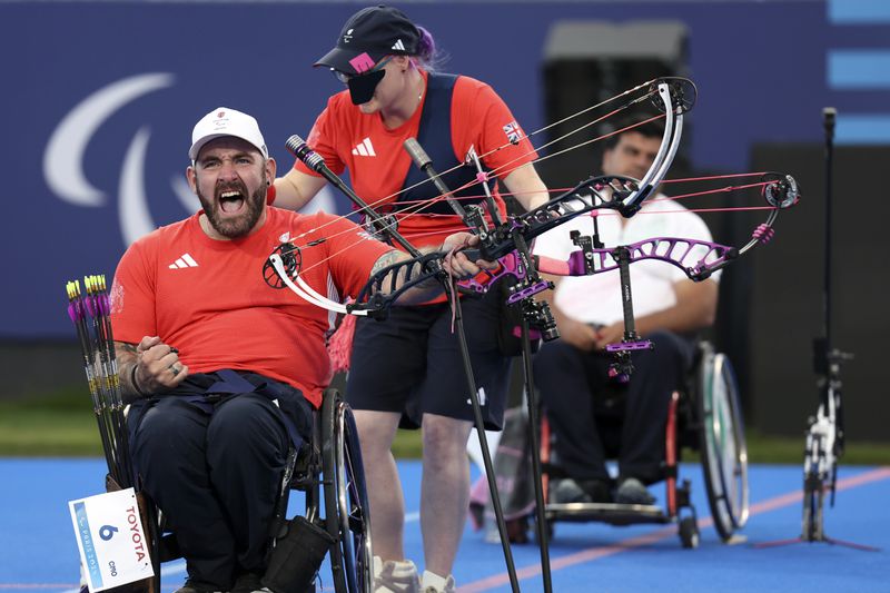 Great Britain's Nathan Macqueen and Jodie Grinham win gold in the Mixed Team Compound Open, during the 2024 Paralympics, Monday, Sept. 2, 2024 in Paris, France. (AP Photo/Leighton Smithwick)