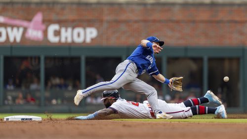 Atlanta Braves' Michael Harris II, bottom, slides successfully into second before Kansas City Royals second baseman Michael Massey, top, can catch the ball in the first inning of a baseball game, Sunday, Sept. 29, 2024, in Atlanta. (AP Photo/Jason Allen)