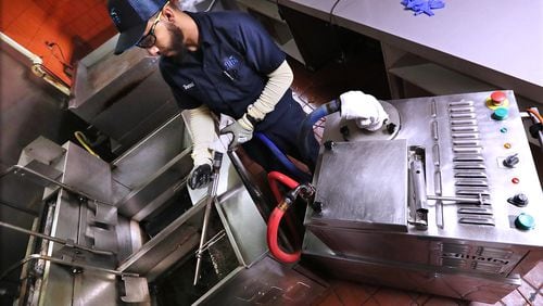 Filta lead technician Donnell Collier users a mobile filtration unit to filter fry oil at a concession stand in the Georgia World Congress Center on Thursday, Jan. 17, 2019, in Atlanta.