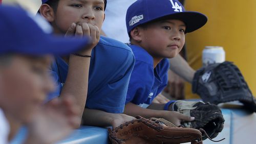 Young fans wait to snag souvenir balls during batting practice before the start of Game 1 of the World Series between the Los Angeles Dodgers and the Houston Astros at Dodger Stadium in Los Angeles on Tuesday, Oct. 24, 2017. (Luis Sinco/Los Angeles Times/TNS)