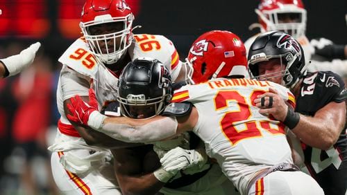 Atlanta Falcons running back Bijan Robinson (7) is tackled by Kansas City Chiefs defensive tackle Chris Jones (95) and Kansas City Chiefs linebacker Drue Tranquill (23) during the fourth quarter at Mercedes-Benz Stadium, Sunday, Sept. 22, 2024, in Atlanta. The Falcons lost 22-17. (Jason Getz / AJC)

