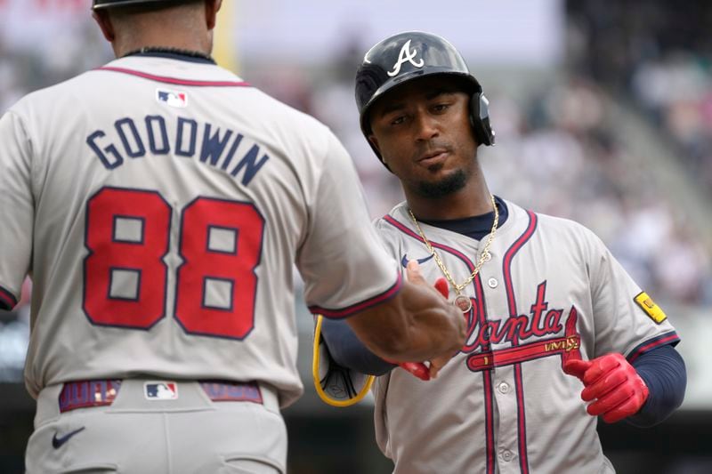 Atlanta Braves' Ozzie Albies, right, celebrates with first base coach Tom Goodwin (88) after hitting a single which led to Orlando Arcia scoring during the fifth inning of a baseball game against the New York Yankees, Sunday, June 23, 2024, in New York. (AP Photo/Pamela Smith)