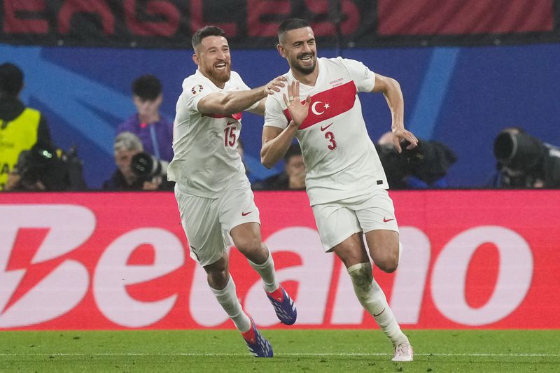 Turkey's Merih Demiral, right, celebrates with Salih Ozcan after scoring his side's second goal during a round of sixteen match between Austria and Turkey at the Euro 2024 soccer tournament in Leipzig, Germany, Tuesday, July 2, 2024. (AP Photo/Martin Meissner)