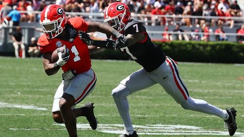 Georgia running back Trevor Etienne catches a pass and picks up yardage past defensive back Daniel Harris during the G-Day game on Saturday, April 13, 2024.  Curtis Compton for the Atlanta Journal Constitution