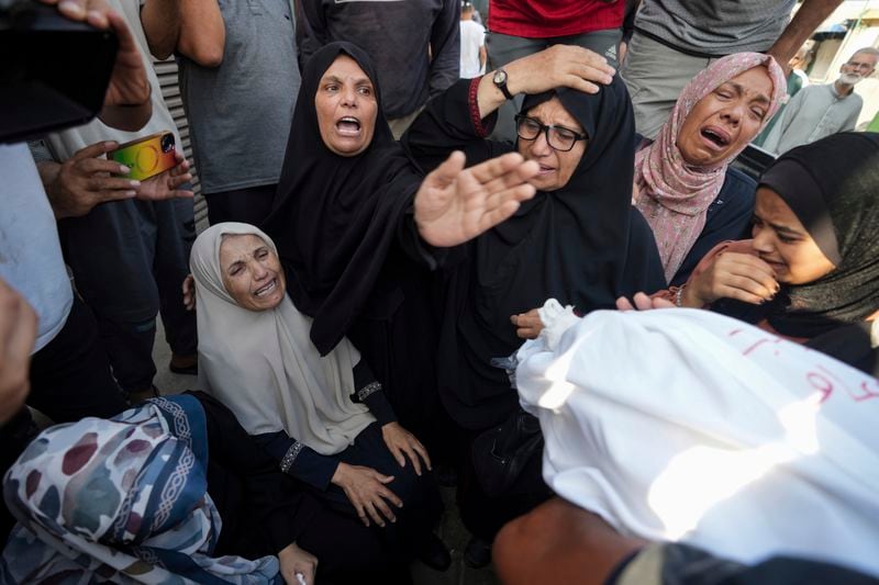 Palestinians mourn relatives killed in the Israeli bombardment of the Gaza Strip, at a hospital in Deir al-Balah, Tuesday, Aug. 27, 2024. (AP Photo/Abdel Kareem Hana)