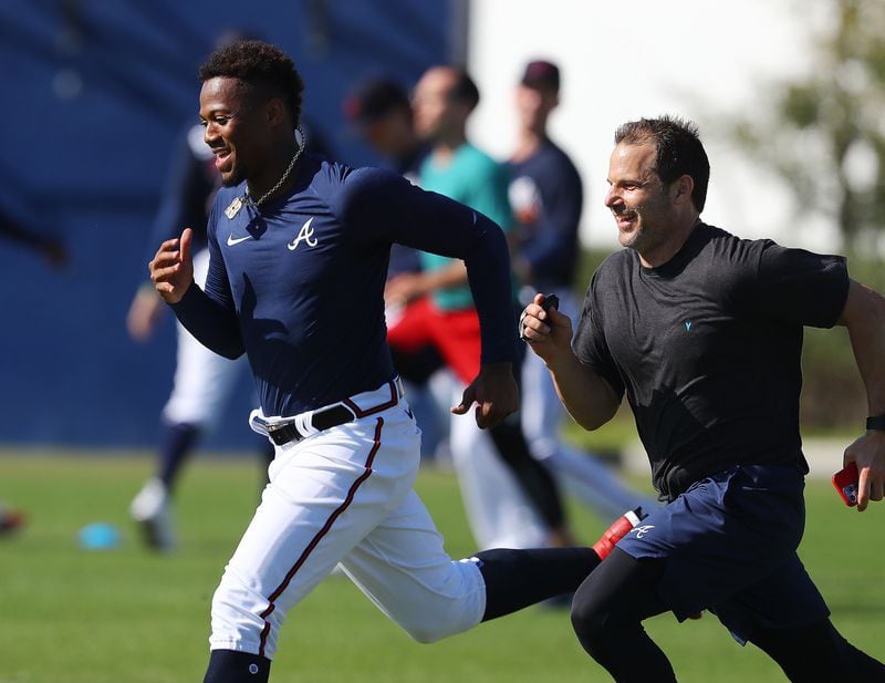 Braves outfielder Ronald Acuna is all smiles as he outruns a trainer while running sprints during spring training in North Port, Fla. (Curtis Compton / Curtis.Compton@ajc.com)