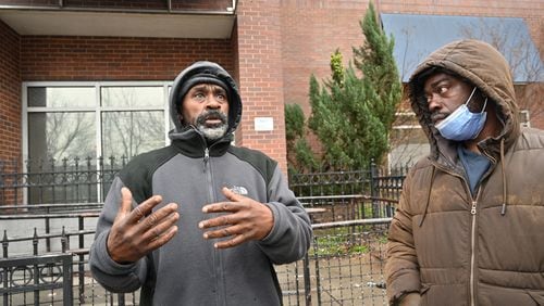 Michael Smith (left) shares his story as Mackendy Pierrette looks outside the Gateway Center in Atlanta on Thursday, January 20, 2022. The Gateway Center is a homeless service center. (Hyosub Shin / Hyosub.Shin@ajc.com)