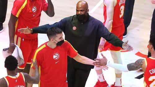 Hawks interim coach Nate McMillan hands out fives to his players during a victory on April 20, 2021. (Curtis Compton / Curtis.Compton@ajc.com)