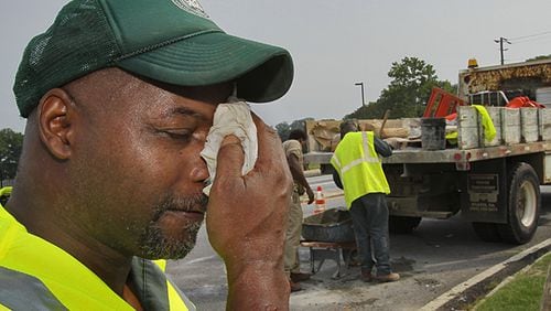 With a heat advisory and heat index topping 100 degrees, Gregory Merchinson, part of a crew with DeKalb County Roads and Drainage, worked at the corner of Briarcliff Road and North Druid Hills Road on a catch basin cave-in seal. There are currently no federal or state regulations specifically protecting outdoor workers from heat illness or death.