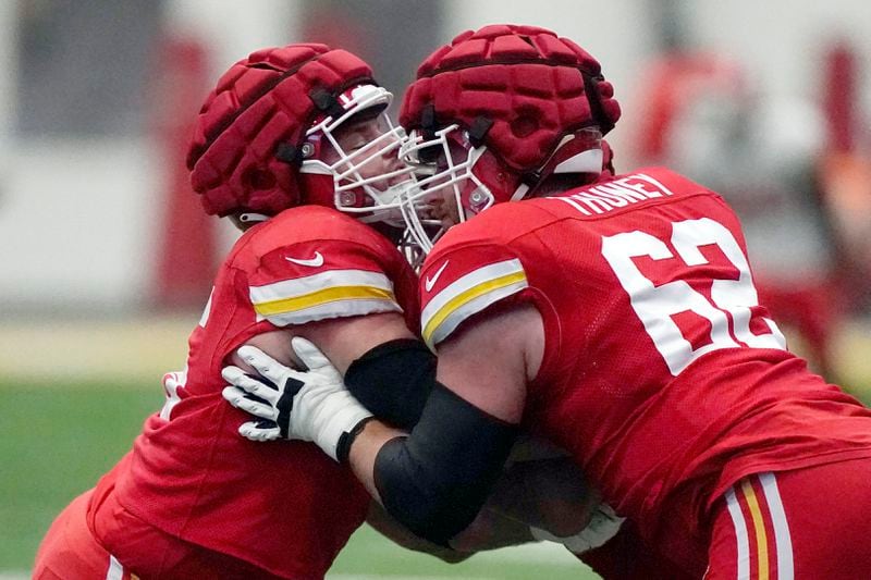 FILE - Kansas City Chiefs guard Vitaliy Gurman, left, and outside linebacker Joe Thuney (62) wear Guardian Caps on their helmets as they participate in a drill at NFL football training camp Wednesday, Aug. 3, 2022, in St. Joseph, Mo. (AP Photo/Charlie Riedel, File)