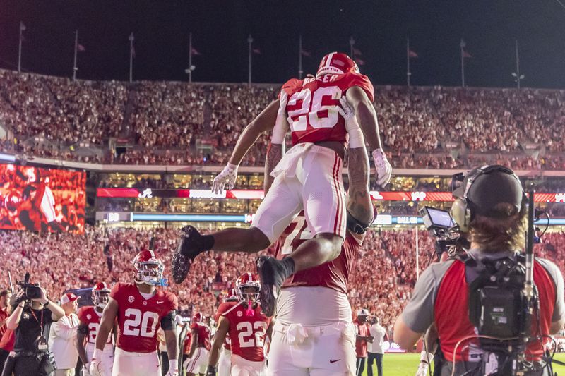 Alabama running back Jam Miller (26) celebrates his touchdown with offensive lineman Kadyn Proctor during the first half of an NCAA college football game against Georgia, Saturday, Sept. 28, 2024, in Tuscaloosa, Ala. (AP Photo/Vasha Hunt)