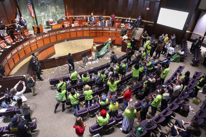 Opponents of the under-construction law enforcement training center known to some as "Cop City" disrupt the City Council meeting at City Hall in Atlanta, Monday, Sept. 16, 2024. (Arvin Temkar/Atlanta Journal-Constitution via AP)