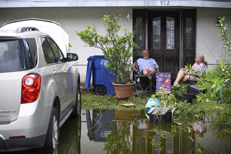 Andy Slone and his wife, Vickie, sit outside their home in the aftermath of Hurricane Helene, Friday, Sept. 27, 2024, in Crystal River, Fla. (AP Photo/Phelan M. Ebenhack)