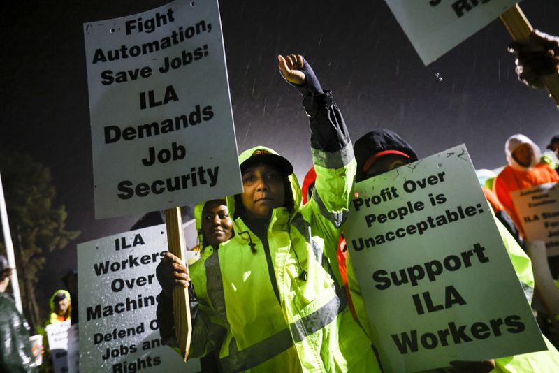 Longshoremen Meikysha Wright and others strike together outside of the Virginia International Gateway in Portsmouth, Va., Tuesday, Oct. 1, 2024. (Billy Schuerman/The Virginian-Pilot via AP)