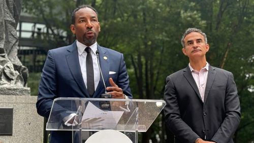 Mayor Andre Dickens (left) announces $60 million in public funding for homelessness at an event at Woodruff Park on Monday, Sept. 3, 2024. Frank Fernandez (right), President and CEO at Community Foundation for Greater Atlanta, said his group had committed $10 million. (Matt Reynolds/AJC)