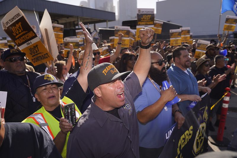 FILE - Teamsters and workers hold a rally in downtown Los Angeles, July 19, 2023, as a deadline neared in negotiations between the union and United Parcel Service. (AP Photo/Damian Dovarganes)