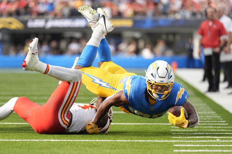 Los Angeles Chargers running back J.K. Dobbins, right, struggles for yardage as Kansas City Chiefs safety Nazeeh Johnson, left, defends during the second half of an NFL football game Sunday, Sept. 29, 2024, in Inglewood, Calif. (AP Photo/Ashley Landis)