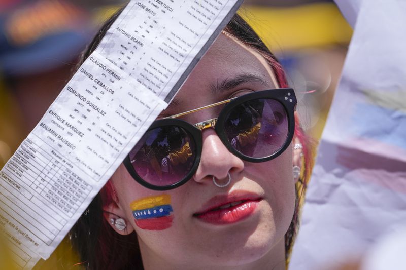 A woman holds up vote tally sheets during a protest against the official results that declared President Nicolas Maduro the winner of the July presidential election, on a public square in Bogota, Colombia, Saturday, Aug. 17, 2024. (AP Photo/Matias Delacroix)