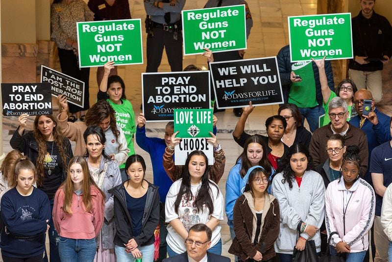 In this file photo, pro-abortion activists and anti-abortion activists hold opposing signs at a rally at the Georgia Capitol in Atlanta. (Arvin Temkar/The Atlanta Journal-Constitution)