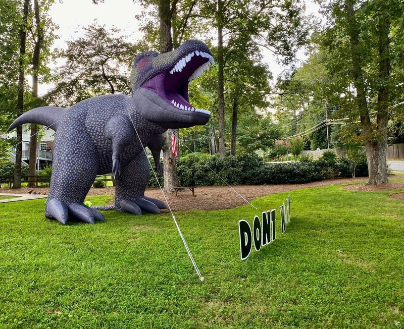 For almost three years, a Dunwoody family has decorated their yard with inflatable dinosaurs and inspirational messages. Following a complaint, the city says the displays violate Dunwoody's sign ordinance and must come down.