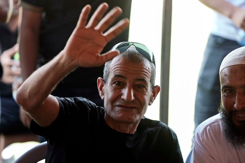 Qaid Farhan Alkadi, 52, who was held hostage by Hamas militants in Gaza Strip, waves to relatives, friends and journalists after arriving in the Khirbet Karkur village, near Rahat, southern Israel, Wednesday, Aug. 28, 2024. (AP Photo/Mahmoud Illean)