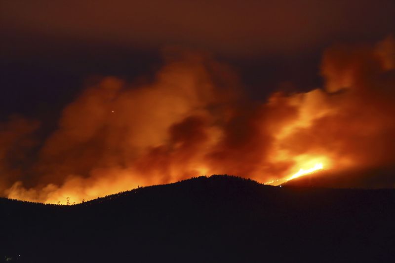 Clouds of smoke drift with the strong wind as fires rage on the hills around Sever do Vouga, a town in northern Portugal that has been surrounded by forest fires, Tuesday, Sept. 17, 2024. (AP Photo/Bruno Fonseca)