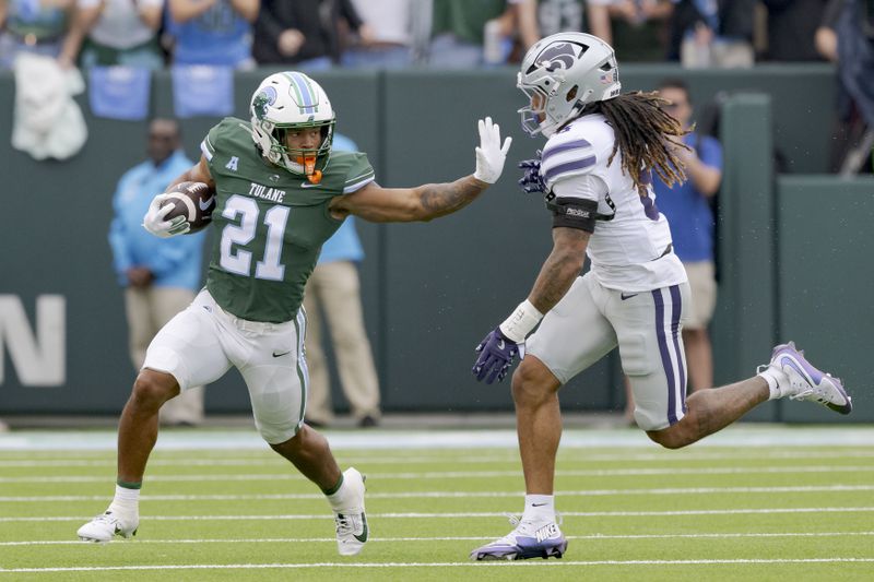 Tulane running back Makhi Hughes (21) runs against Kansas State safety Jordan Riley (6) during the first half of an NCAA college football game in New Orleans, Saturday, Sept. 7, 2024. (AP Photo/Matthew Hinton)