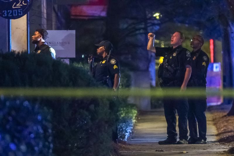 Atlanta police canvass the area outside a northwest Atlanta barber shop for evidence following a fatal shooting Wednesday morning.