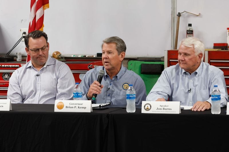 Gov. Brian Kemp (center) speaks at a roundtable discussion in Atlanta on Thursday as Lt. Gov. Burt Jones (left) and Georgia House Speaker Jon Burns (right) listen.  