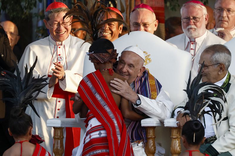 Pope Francis hugs a child as East Timor President Jose Ramos-Horta sits with him during a welcoming ceremony upon meeting at the Presidential Palace in Dili, East Timor, Sept.9, 2024. In East Timor Francis had to negotiate perhaps the most sensitive issue clouding the visit to Asia and Oceania : the case of Bishop Carlos Ximenes Belo, the revered national hero who won the Nobel Peace Prize for his nonviolent independence campaign. (Willy Kurniawan/Pool Photo via AP)