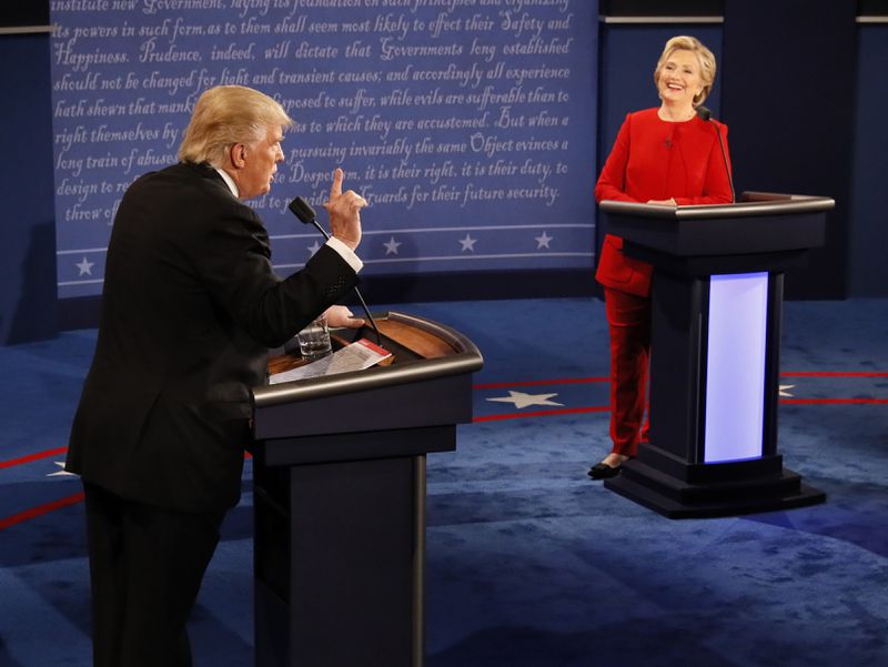 FILE - Democratic presidential nominee Hillary Clinton smiles as Republican presidential nominee Donald Trump speaks during the presidential debate in Hempstead, N.Y., Sept. 26, 2016. (Rick T. Wilking/Pool via AP, File)