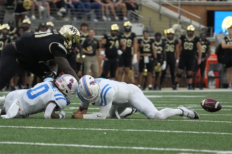 Mississippi quarterback Jaxson Dart, right, fumbles the ball as running back Matt Jones (0) and Wake Forest's Kevin Pointer (91) close in during the first half of an NCAA college football game in Winston-Salem, N.C., Saturday, Sept. 14, 2024. Wake Forest recovered the ball. (AP Photo/Chuck Burton)