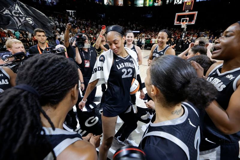 Las Vegas Aces center A'ja Wilson, center, celebrates with teammates after an WNBA basketball game against the Connecticut Sun, Sunday, Sept. 15, 2024, in Las Vegas. Wilson scored 29 points in the game to become the first WNBA player in WNBA history to reach 1,000 points in a regular season. (Steve Marcus/Las Vegas Sun via AP)