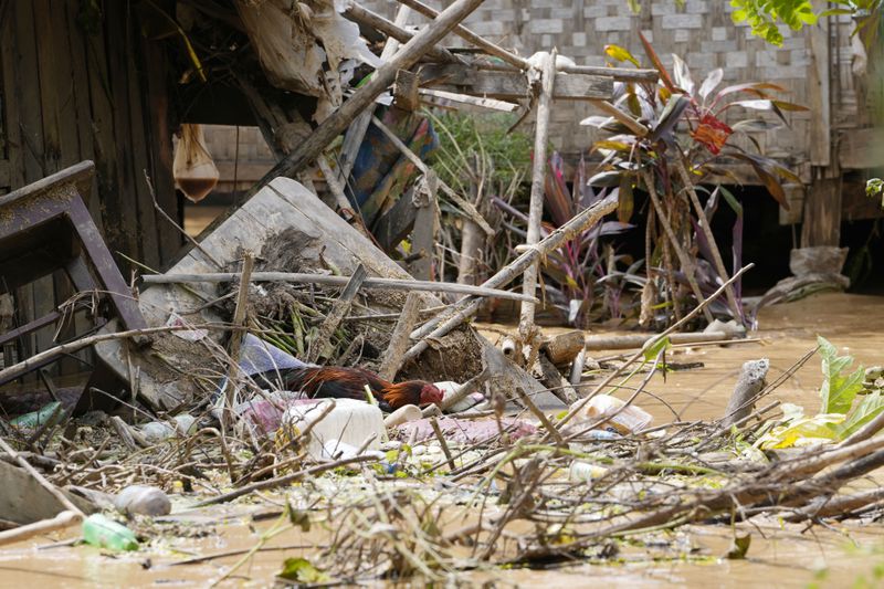 Debris from half-submerged residences gather on a flooded road in Naypyitaw, Myanmar, Saturday, Sept. 14, 2024. (AP Photo/Aung Shine Oo)