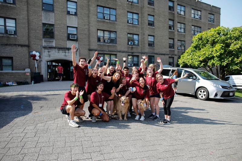 Tania Tetlow, president of Fordham University, and her dog Archie, pose with students during Move In Day at the Bronx campus, Sunday, Aug. 25, 2024, in New York. (AP Photo/Kena Betancur)