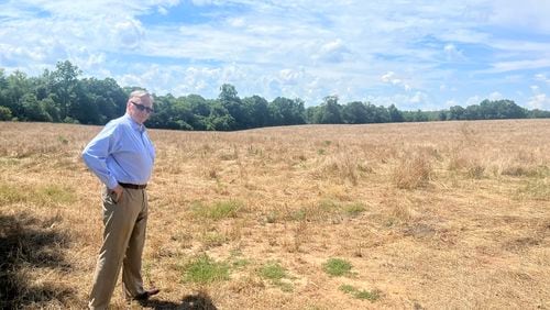 Ed Whitehouse, a consultant for a local company called Interstate Health Systems, stands on a plot of land in rural Butts County, Georgia. The company envisions replacing acres of farmland and trees with a new hospital. A recent change to Georgia law is giving the project a path forward. (Andy Miller for KFF Health News) 