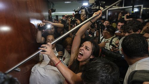 Protesters attempt to break into a room in the Senate as lawmakers weigh the government's proposed judicial reform, which would make judges stand for election, in Mexico City, Tuesday, Sept. 10, 2024. (AP Photo/Felix Marquez)