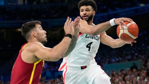 FILE - Jamal Murray, right, of Canada, looks to pass the ball around Willy Hernangomez, left, of Spain, in a men's basketball game at the 2024 Summer Olympics, Aug. 2, 2024, in Villeneuve-d'Ascq, France. (AP Photo/Mark J. Terrill, File)