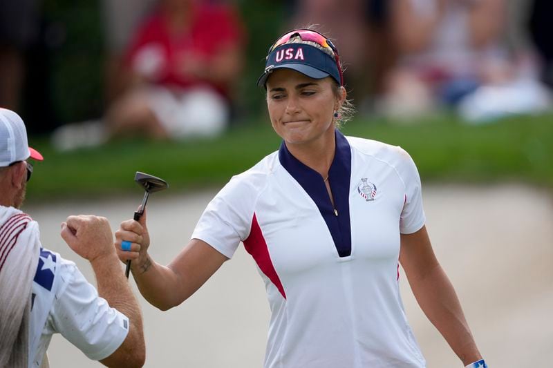 United States' Lexi Thompson bumps fists with her caddie after making a putt on the seventh green during a Solheim Cup golf tournament singles match at the Robert Trent Jones Golf Club, Sunday, Sept. 15, 2024, in Gainesville, Va. (AP Photo/Matt York)