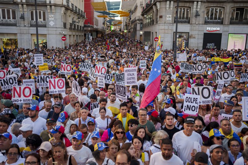 People take part during a protest against the official results that declared President Nicolas Maduro the winner of the July presidential election in Madrid, Spain, Saturday, Aug. 17, 2024. Banners reads in Spanish: "For the freedom of the Venezuelan people". (AP Photo/Manu Fernandez)