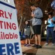 Josh Weeks waits in line with son, Noah-4 as early voters hit the polls Friday, Nov. 4, 2022 at the Joan P. Garner Library in Atlanta.  (John Spink / John.Spink@ajc.com)