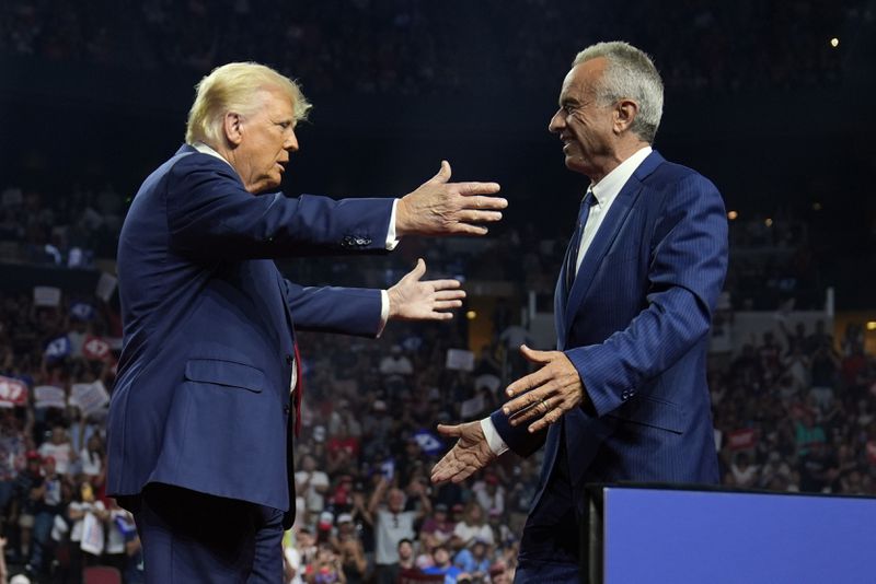 Republican presidential nominee former President Donald Trump embraces Independent presidential candidate Robert F. Kennedy Jr. after getting his endorsement at a campaign rally at the Desert Diamond Arena, Friday, Aug. 23, 2024, in Glendale, Ariz. (AP Photo/Evan Vucci)