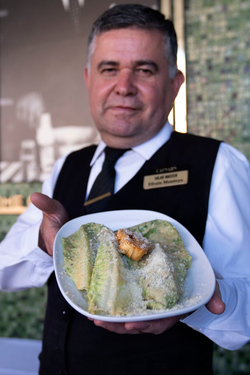 Salad Master Efrain Montoya poses holding a Caesar salad at Ceasar's restaurant Thursday, June 27, 2024, in Tijuana, Mexico. Caesar salad has something to celebrate: It's turning 100. Italian immigrant Caesar Cardini is said to have invented the dish on July 4, 1924, at his restaurant, Caesar's Place, in Tijuana, Mexico. (AP Photo/Gregory Bull)